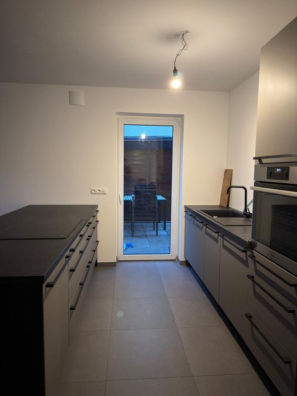 In einem Neubau steht eine komplett montierte Küchenzeile samt Kochinsel und Einbaugeräten