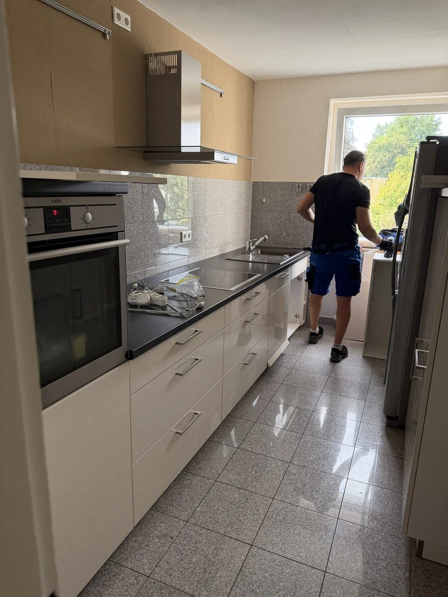Ein Kollege arbeitet seitlich an einer Küchenarbeitsplatte während der Montage