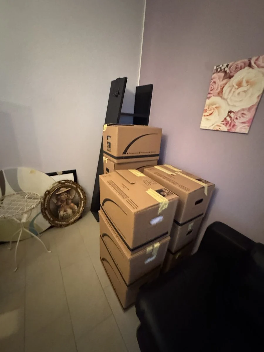 Leicht unaufgeräumtes Zimmer mit Kartons und einem Lautsprecher mitten im Packen