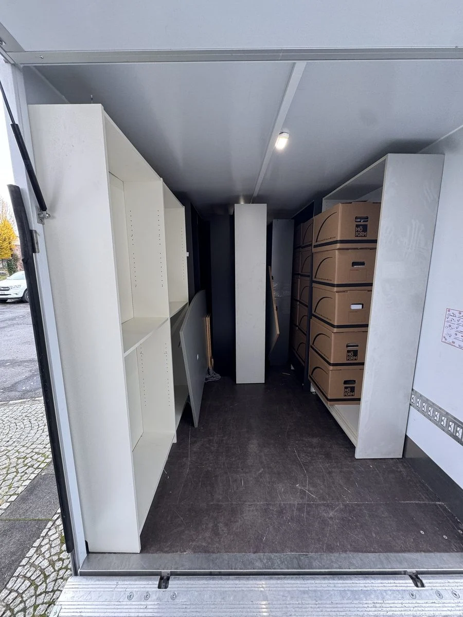 Blick durch die offenen Türen in einen LKW, der mit Schränken beladen ist