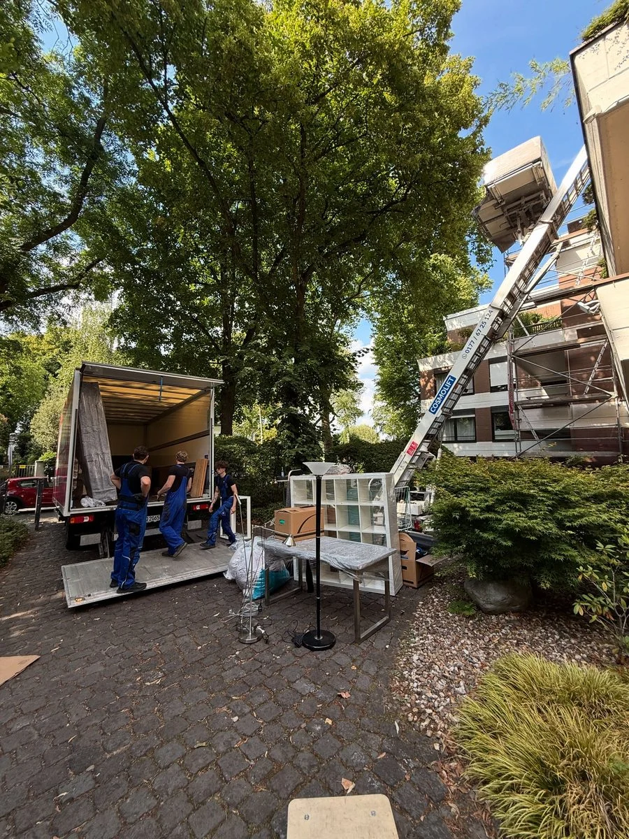 Das Team fährt den Möbellift an einem Baum vorbei zur Beladung