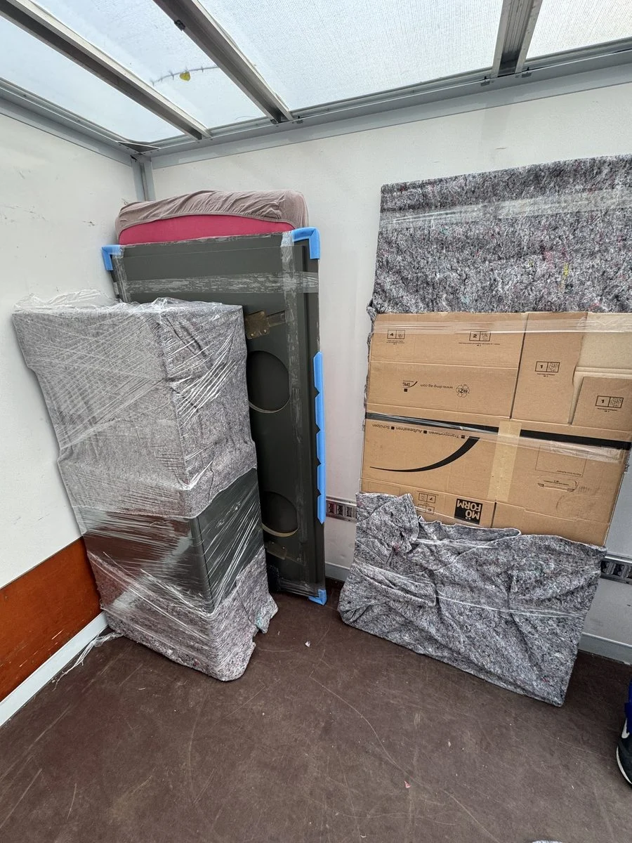 Verpackte Möbelstücke stehen in der Ecke eines Wintergartens bereit
