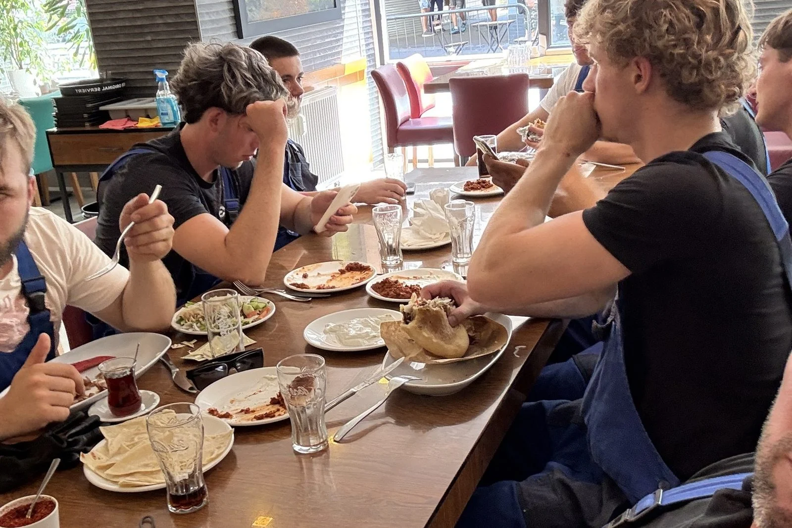 Das Team sitzt in der Pause gemeinsam am Tisch und isst zusammen